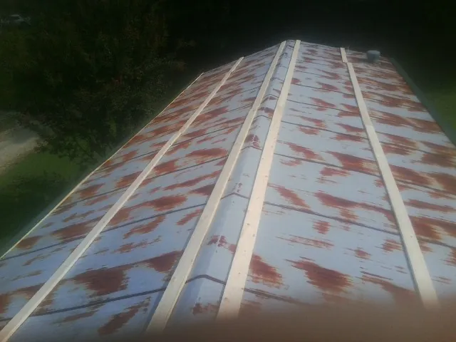 Rusted metal roof panels with new wood purlins before replacement — Storm Damage Roof Repair in Dunkirk by Roofing Brothers