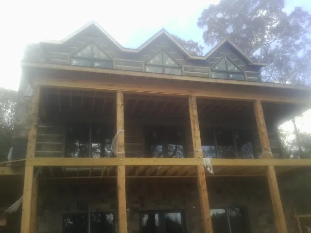 Dormers and porch framing on a large log home under construction — Roof Coating work by our crew in Dunkirk